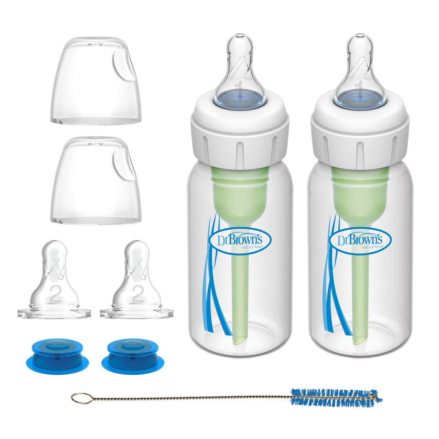 Two Dr. Brown’s® Specialty Feeding System bottles (2 Count) with green internal vents, clear caps, extra silicone nipples, blue discs, and a small cleaning brush are displayed on a white background.