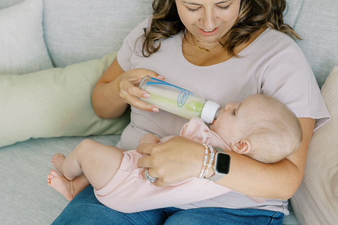 Mom feeding her baby with a glass Dr. Brown's bottle