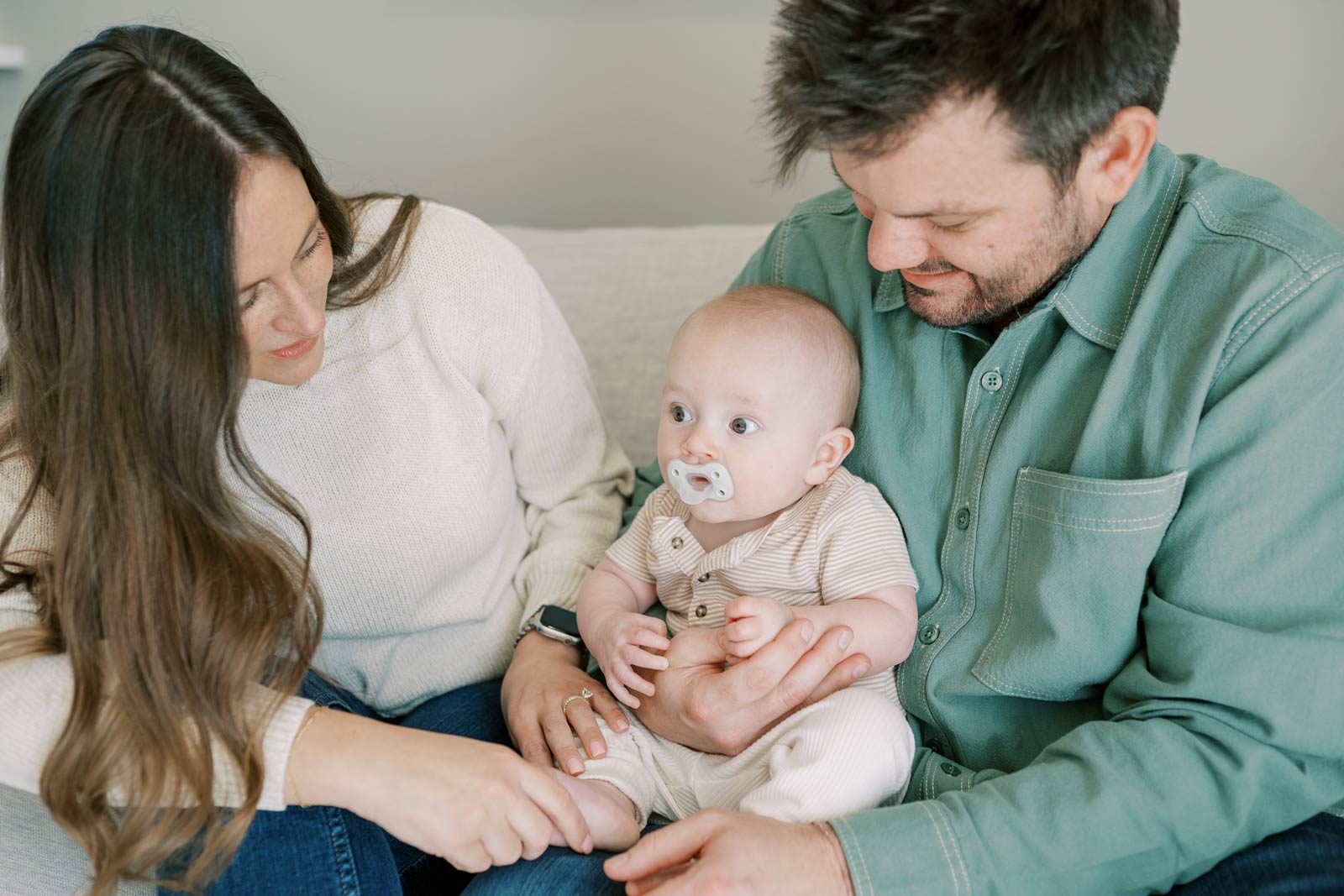 Parents sitting with infant on a couch