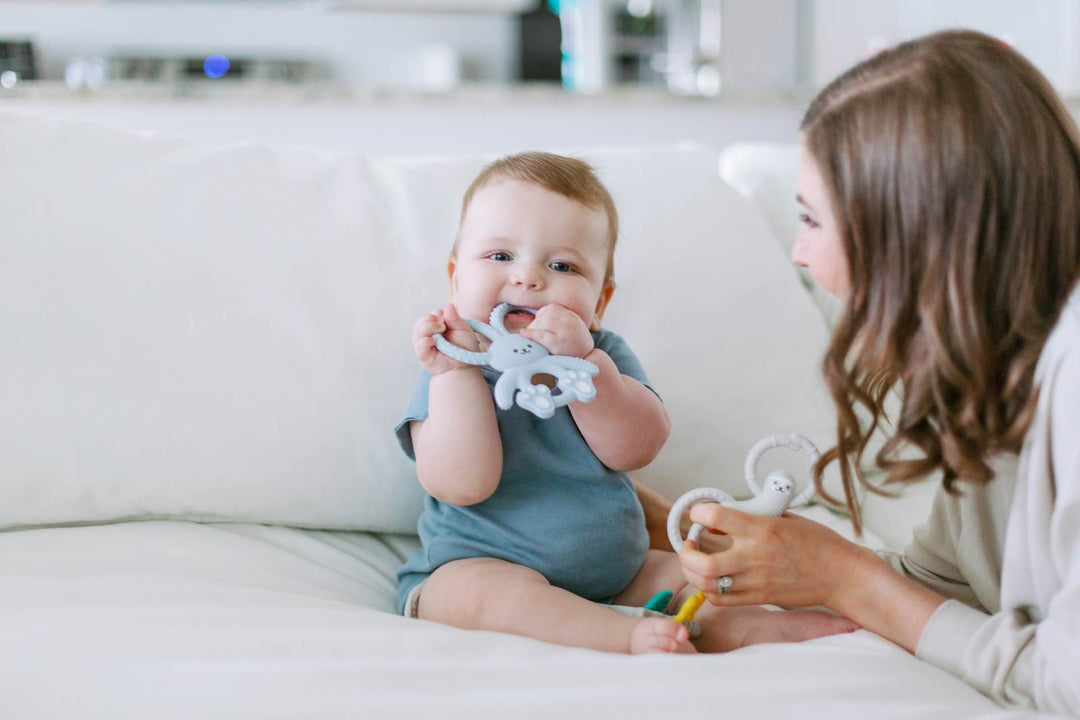 Mother watching her infant use a teether