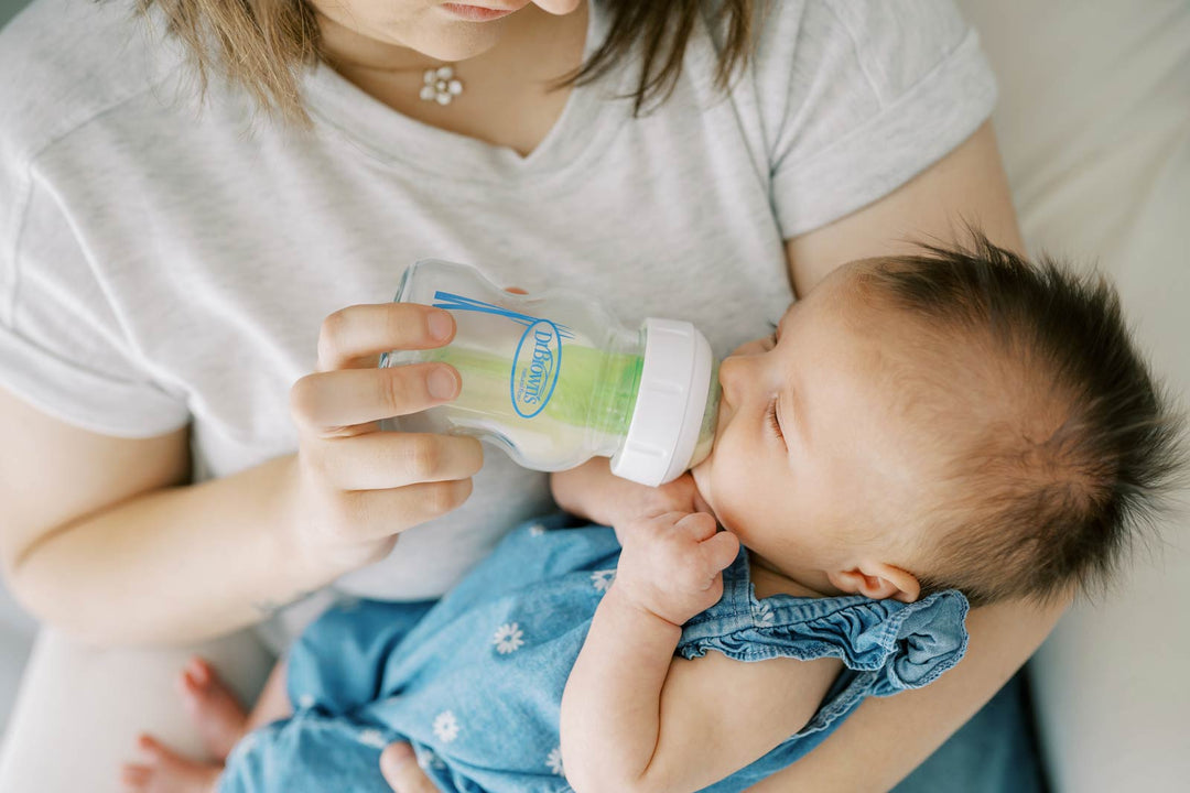 Mother bottle feeding her infant