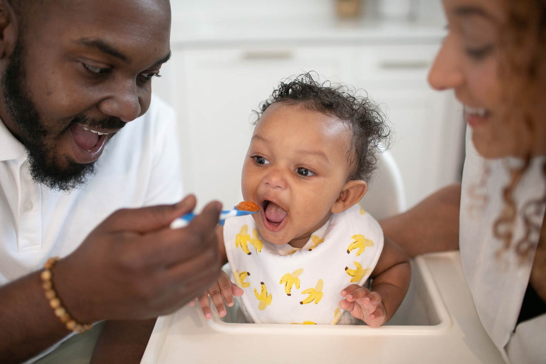 Parents feeding toddler solid foods