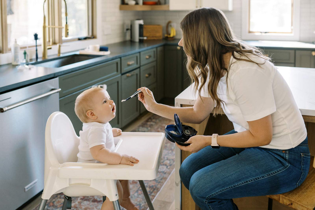 Mother feeding baby solid foods with spoon