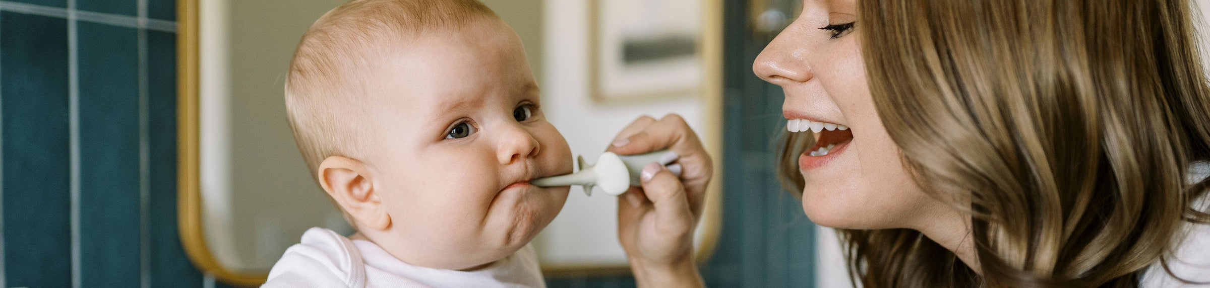 Parent brushing baby's teeth