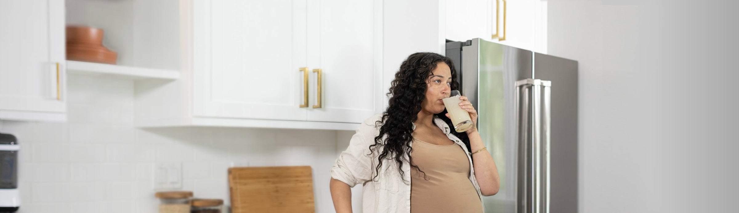 Pregnant woman standing in kitchen drinking Dr. Brown's Sweetie Pie drink.