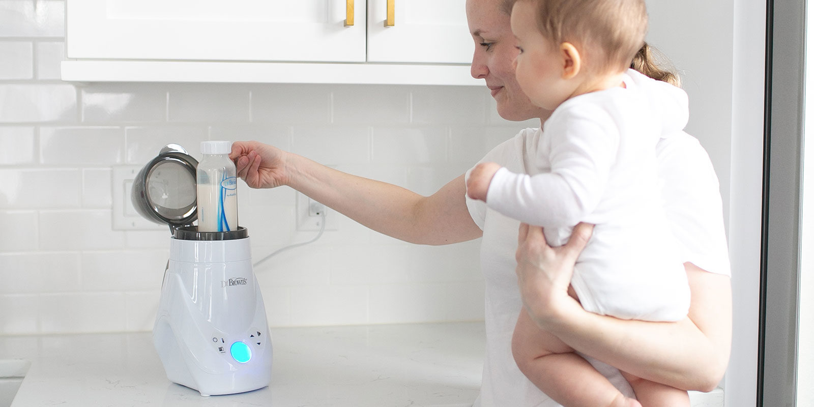 Three bottles on kitchen counter with pink, blue, and teal silicone handles