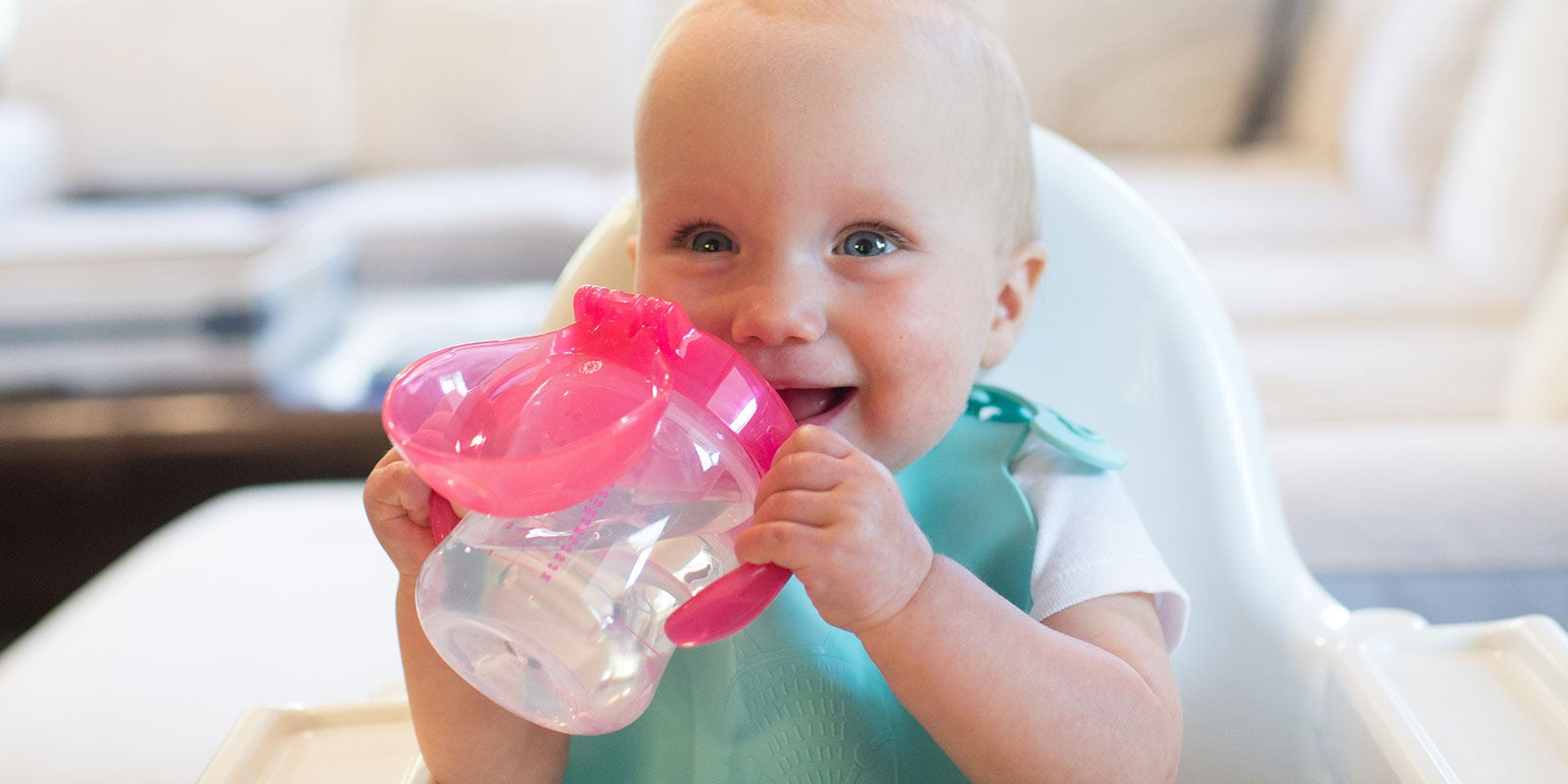 baby drinking from Dr. Brown's Soft Spout Sippy Cup in a highchair