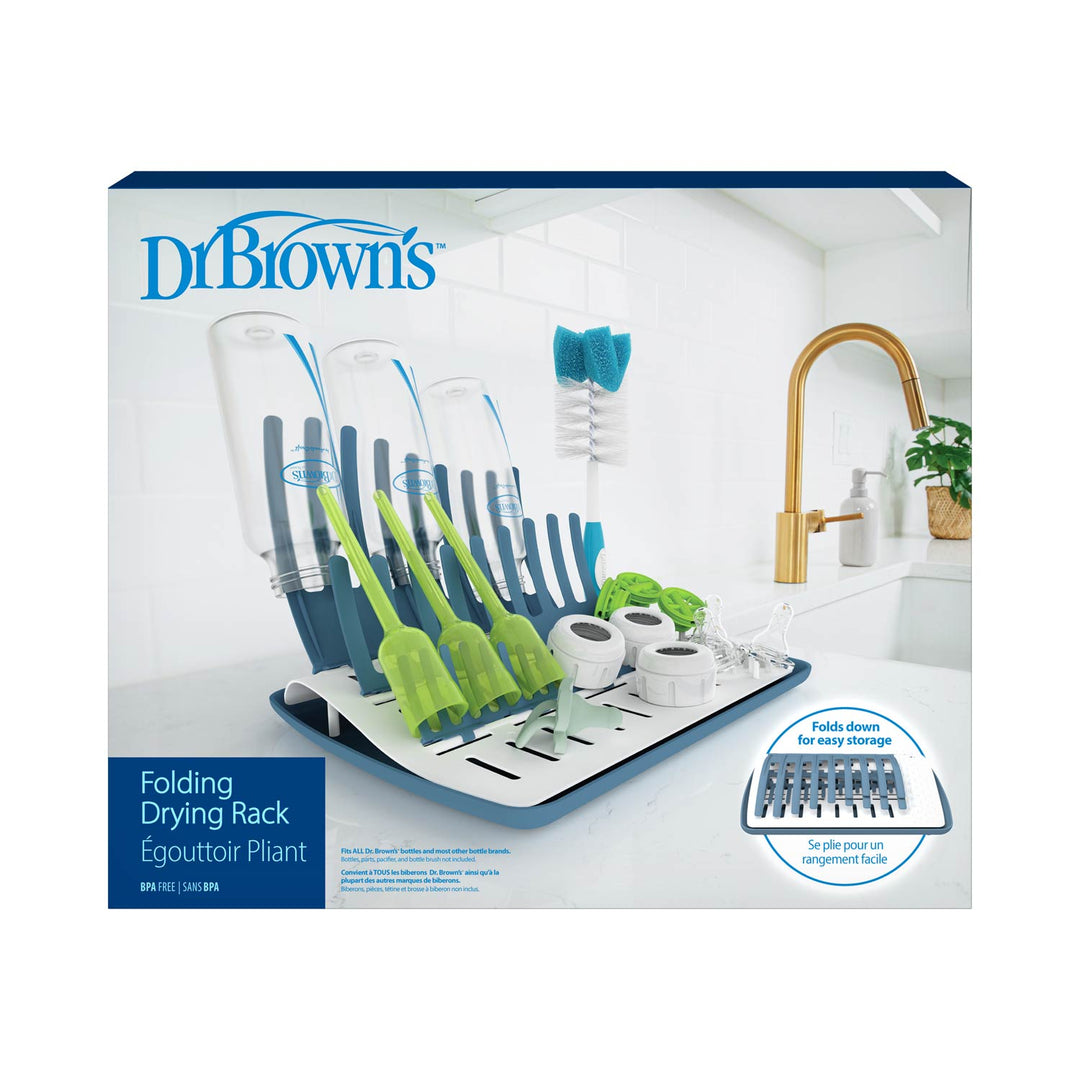 Dr. Brown's™ Folding Baby Bottle Drying Rack packaging highlights its convenience for drying Dr. Brown's bottles and accessories. The blue and white rack holds bottle parts, a brush, and a pacifier, folding easily for storage with a kitchen sink featuring a gold faucet in the background.