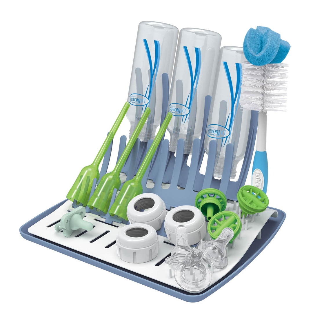 Dr. Brown's™ Folding Baby Bottle Drying Rack features a universal design that holds four inverted bottles, including Dr. Brown's ones, four green brushes, and various baby accessories. It includes a sponge-tipped brush on the side. The blue and white rack has gray sections for organizing.