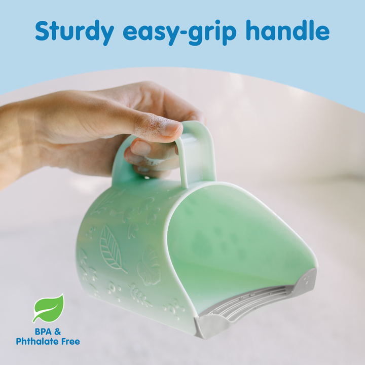 Green Dino-Pour with sturdy easy-grip handle held by a hand on a light background