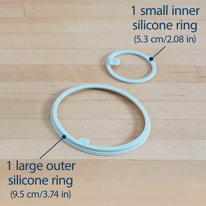 Two silicone rings labeled '1 large outer silicone ring' and '1 small inner silicone ring' on a wooden surface.