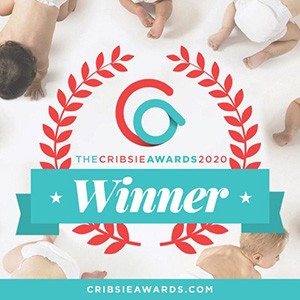 Image of the Cribsie Awards 2020 Winner badge. It features a circular logo with red laurel branches, a teal ribbon with "Winner" written on it, and several babies lying around the edges in a white background.