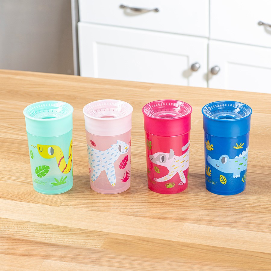 Four colorful sippy cups with different animal designs (snake, sloth, lemur, and crocodile) are lined up on a wooden kitchen counter. Each cup has a unique color: mint green, pink, red, and blue. White cabinets are visible in the background.