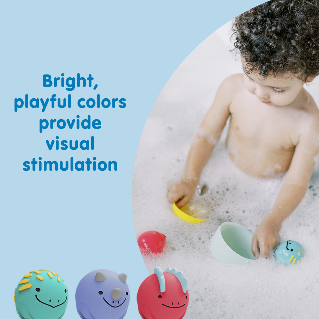 A toddler enjoys Dr. Brown's™ CleanUp™ Float & Hatch Dino Eggs—colorful baby bath toys that provide visual stimulation—in a bubbly tub. Text: "Bright, playful colors provide visual stimulation.