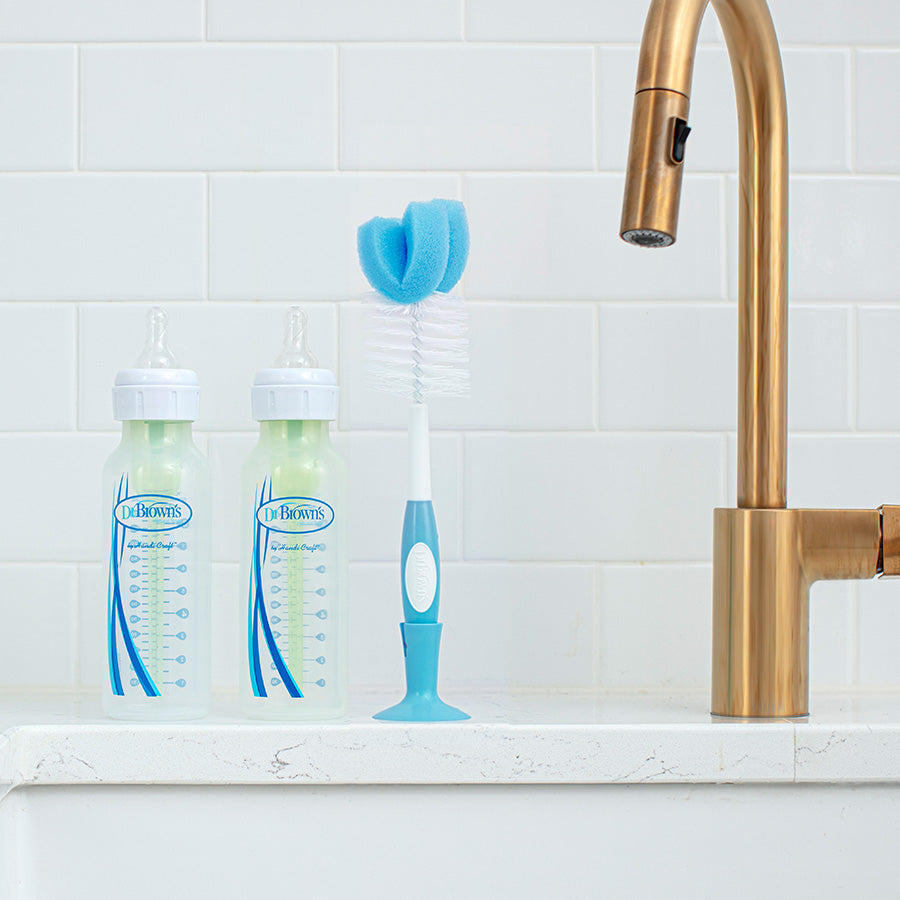 Dr. Brown's Bottle Brush by the kitchen sink with two Dr. Brown's Natural Flow bottles.