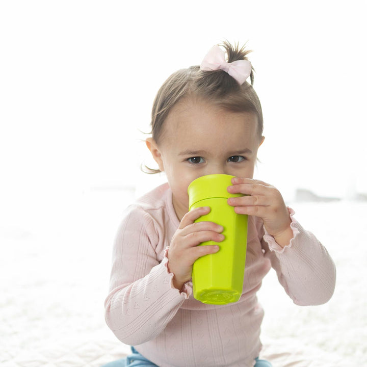 Child sipping out of a green cup