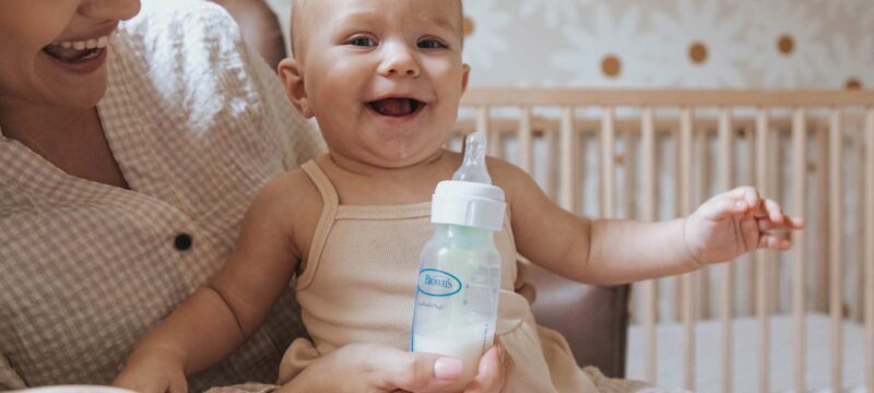 Parent holding infant and Dr. Brown's bottle