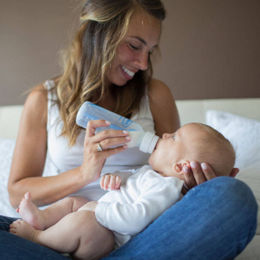 women feeding baby with baby bottle