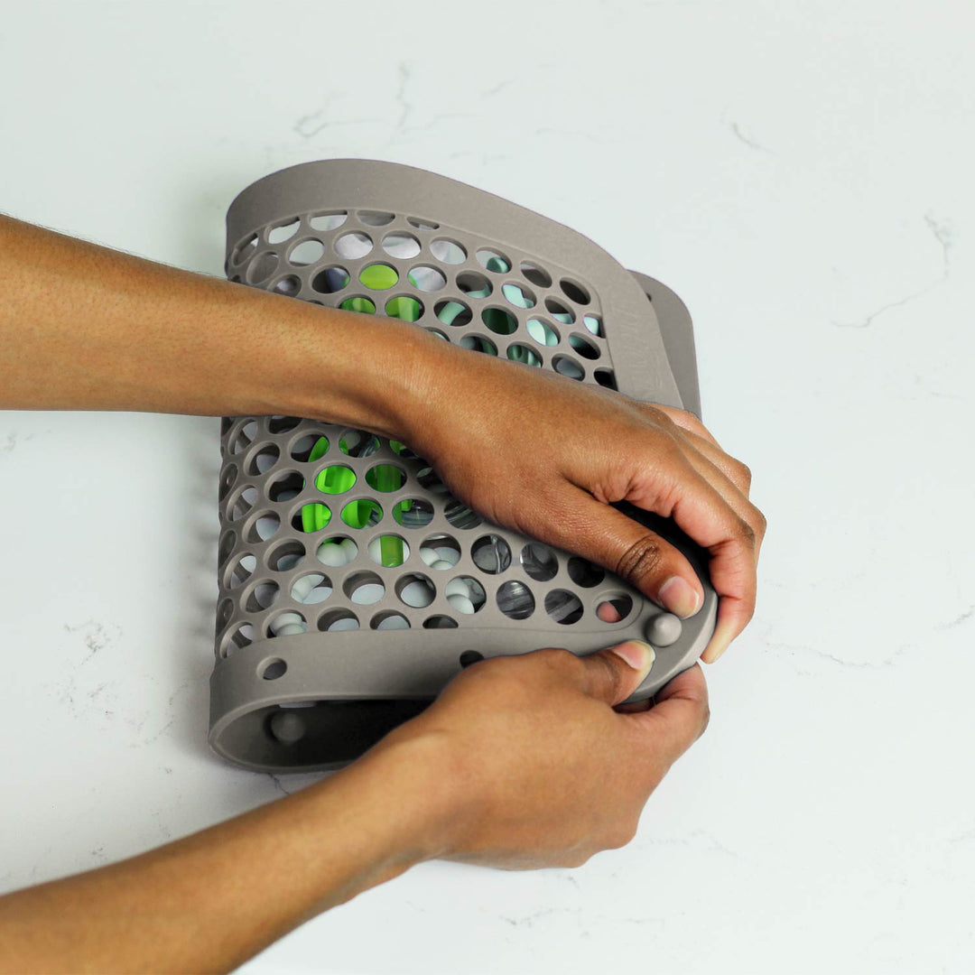 Person closing a gray dishwasher bag