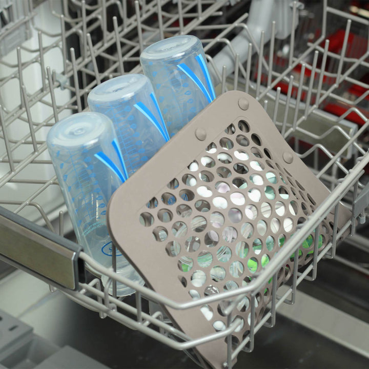 Gray dishwasher bag inside dishwasher next to baby bottles