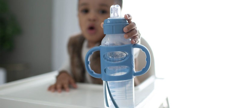 Baby in high chair reaching for Dr. Brown's Sippy Bottle