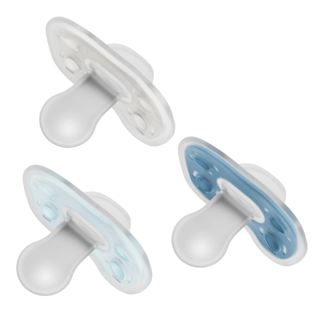 Dr. Brown's® Advantage™ One-Piece Silicone Pacifier – 3-Pack is shown in white, light blue, and blue. Each pacifier features a rounded nipple, flat shield, and seamless one-piece design for baby's comfort on a white background.