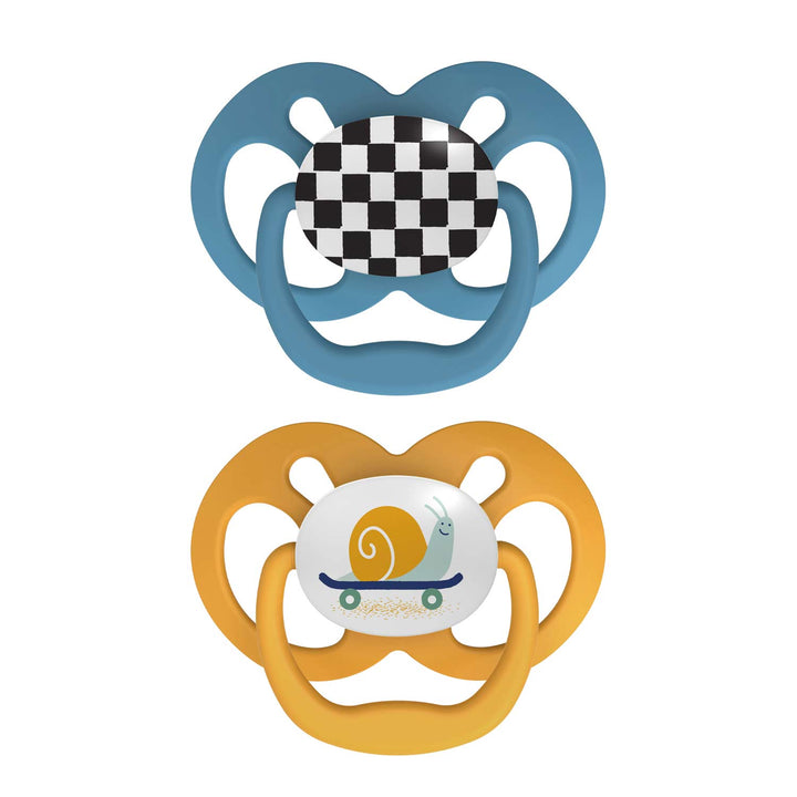 The image showcases two baby pacifiers: a Dr. Brown's Advantage Pacifier in blue with a checkered center on top, and an orange symmetrical pacifier with a whimsical snail on a skateboard below.