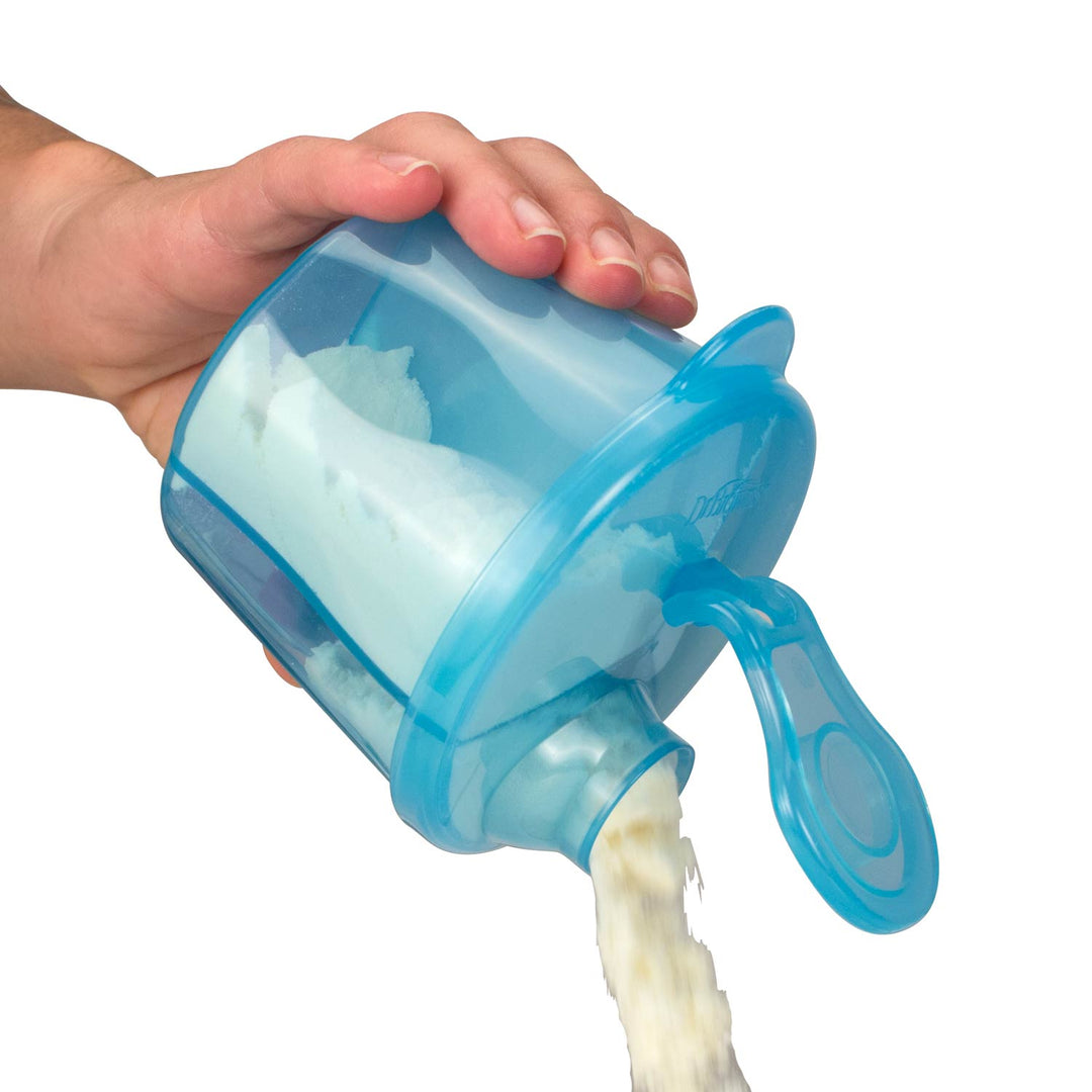A hand holding a translucent blue formula dispenser with a pouring spout, with a white powder or granular substance being poured out.