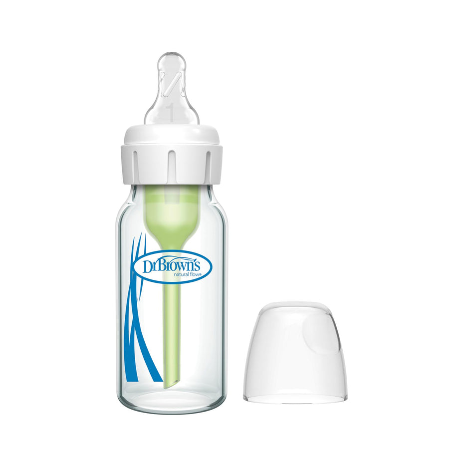 A Dr. Brown’s Natural Flow® Anti-Colic Options+™ Narrow Glass Baby Bottle with a Level 1 Slow Flow Nipple is shown with a white cap, green vent system, and a separate transparent bottle cap.
