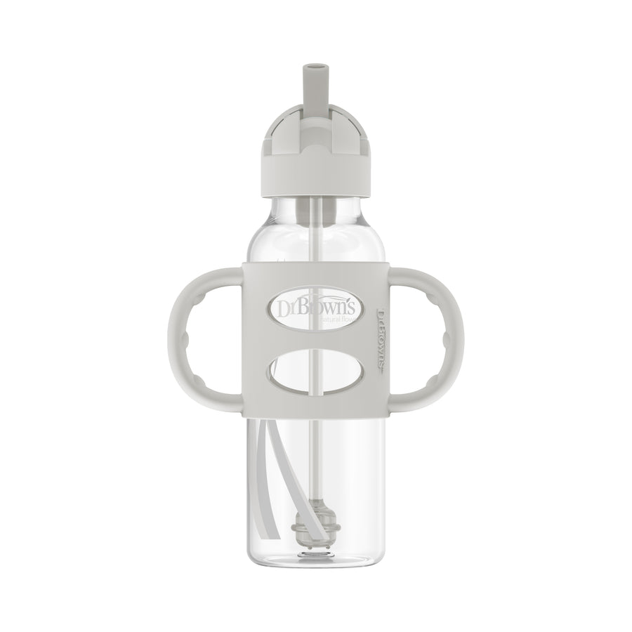 The Dr. Brown's™ Milestones™ Narrow Sippy Straw Bottle with Silicone Handles, 8 oz/250 mL, is a transparent bottle featuring a gray, two-handled silicone grip and a built-in straw to encourage independent drinking skills. It comes with a spill-proof lid and a flip-top spout, ideal for toddlers, while prominently displaying the Dr. Brown's branding on the front.