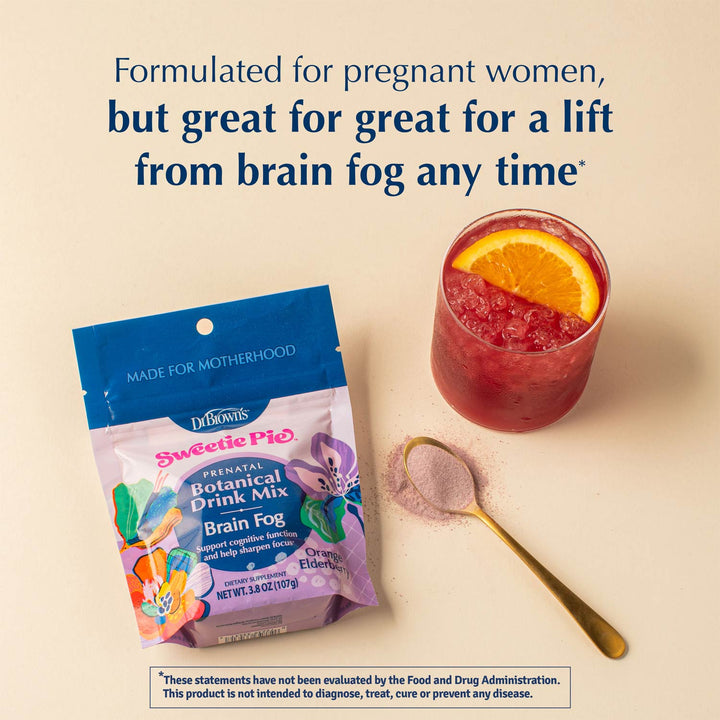 A package of Dr. Brown's Sweetie Pie Prenatal Botanical Drink Mix Brain Fog is shown next to a glass of pinkish-red drink with an orange slice and a gold spoon with powder, on a beige background with promotional text.