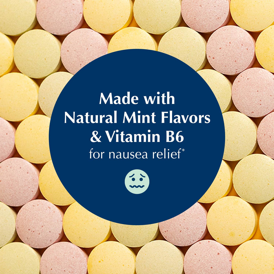A close-up of round pastel tablets in pink and pale yellow, with a large dark blue oval overlay in the center containing white text that reads, 'Made with Natural Mint Flavors & Vitamin B6 for nausea relief' and a small nauseated face icon.