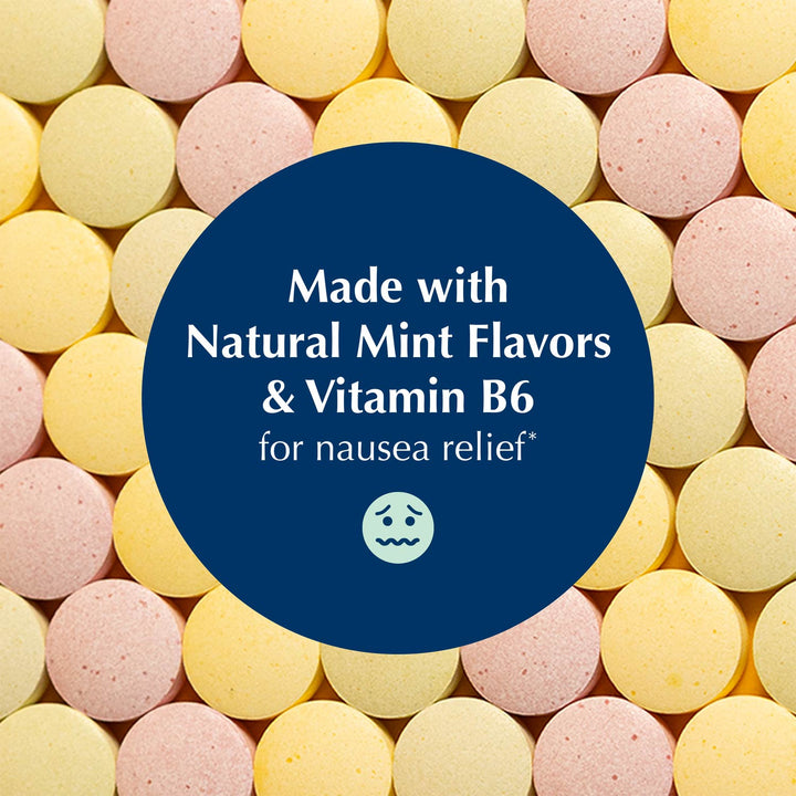 A close-up of round pastel tablets in pink and pale yellow, with a large dark blue oval overlay in the center containing white text that reads, 'Made with Natural Mint Flavors & Vitamin B6 for nausea relief' and a small nauseated face icon.