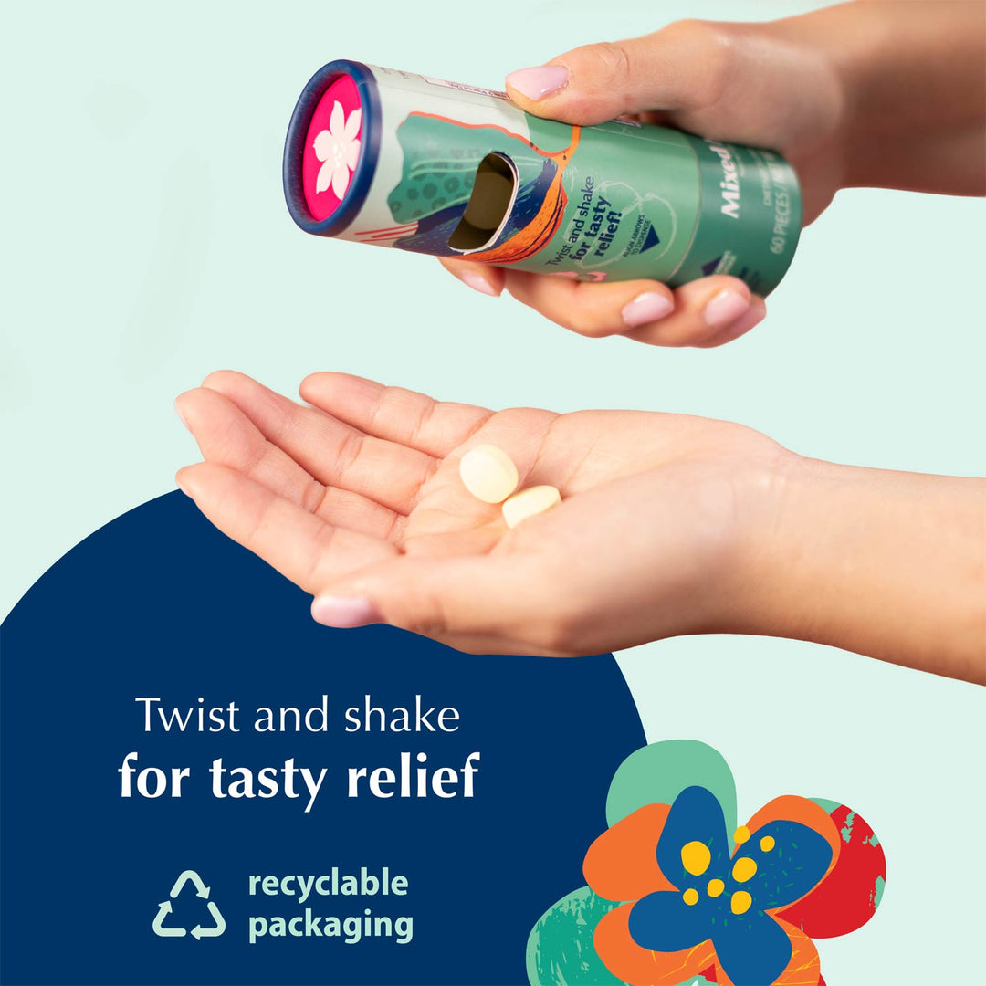 A person holds a green cylindrical tube of Nausea Candies and shakes it over their open palm, with a few white tablets falling out. The background is a light mint green with a dark blue graphic shape and text reading 'Twist and shake for tasty relief' and 'recyclable packaging.