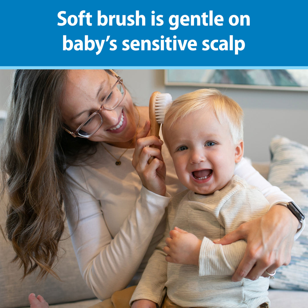 Woman brushing a baby's hair with a soft brush, smiling. Text at the top says, "Soft brush is gentle on baby's sensitive scalp."