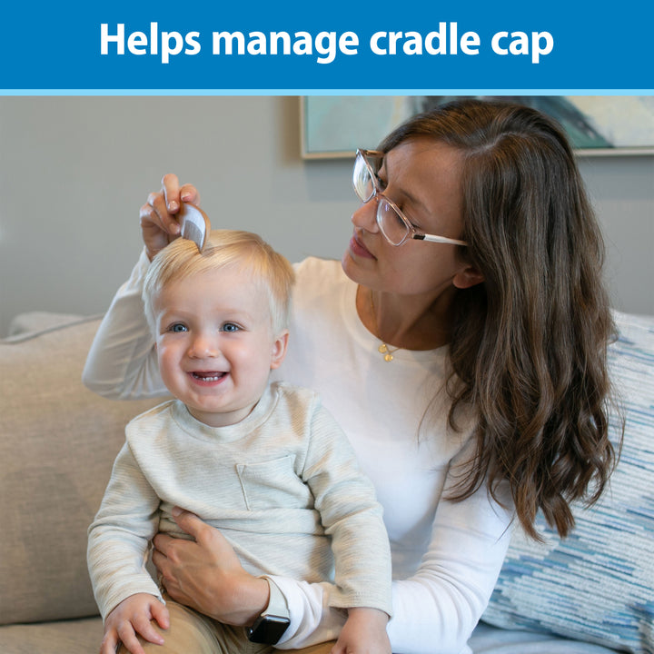 Woman with glasses holding a baby and using a cradle cap treatment tool, with text 'Helps manage cradle cap' on a blue background.