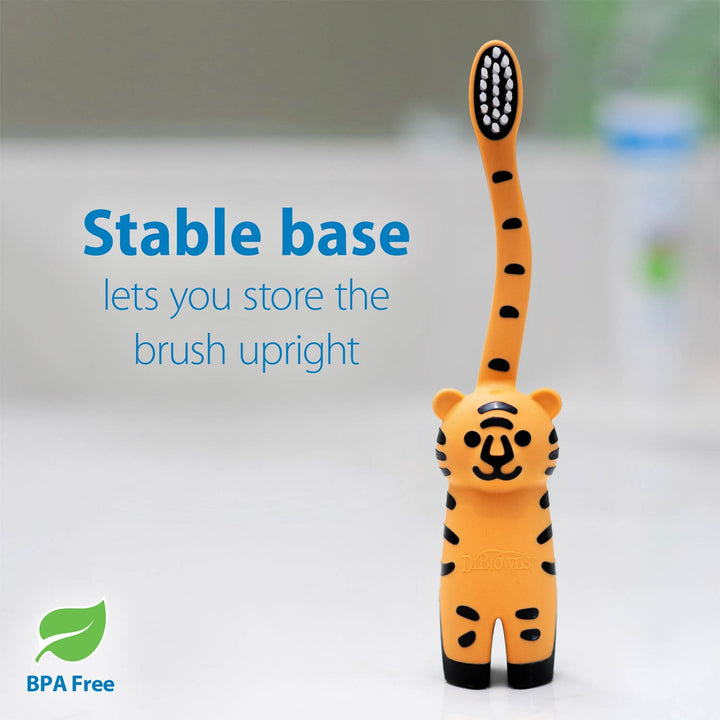 An orange and black tiger-shaped toothbrush stand holding a toothbrush upright, with blue text reading 'Stable base lets you store the brush upright' and a green 'BPA Free' leaf icon on a light gray background.