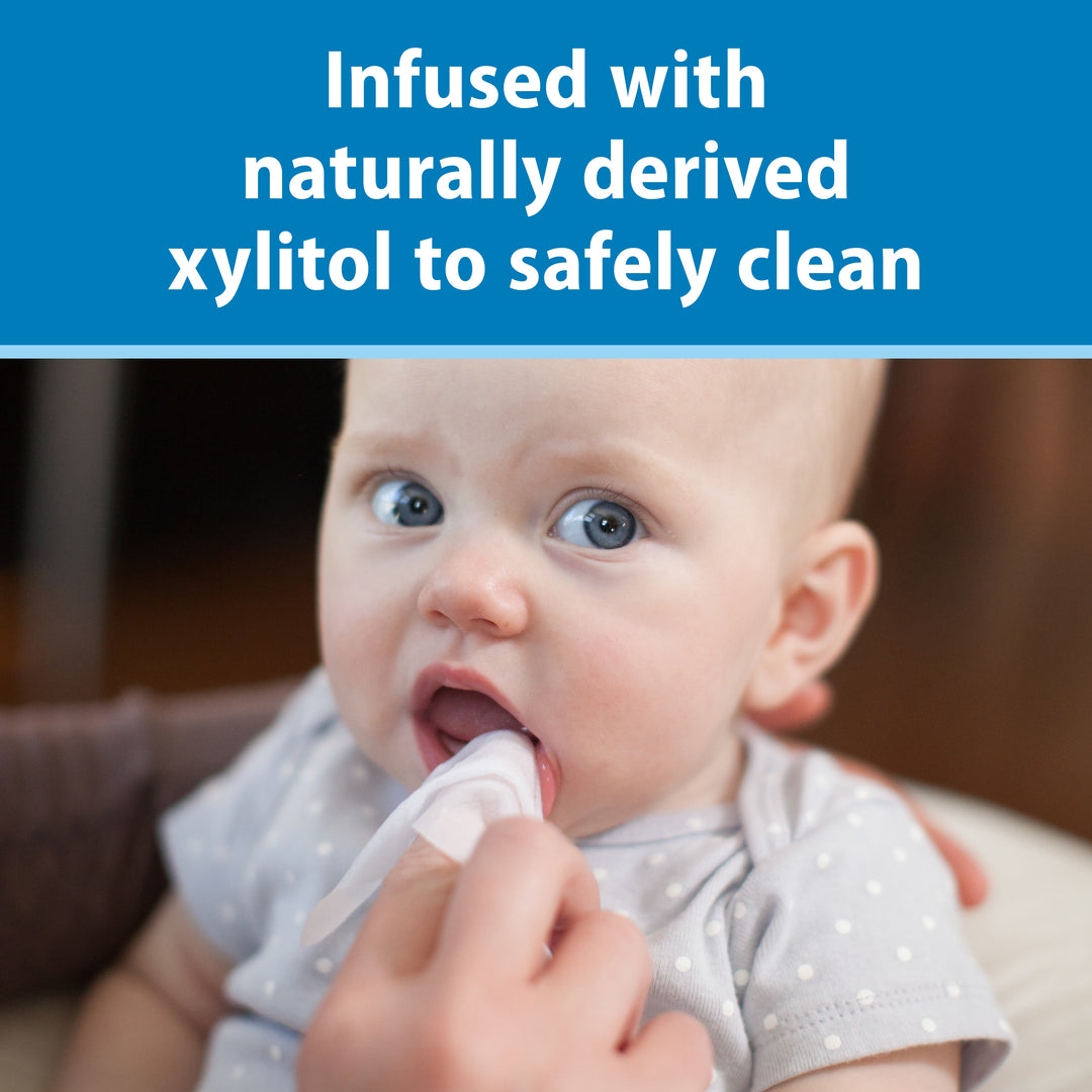 Baby being given a Dr. Brown's Tooth and Gum Wipe with text about naturally derived xylitol.