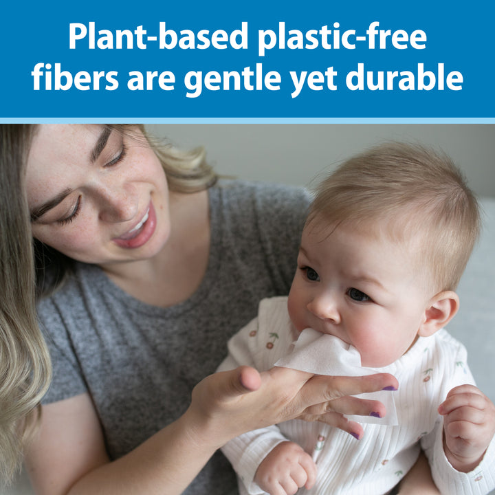 Woman holding a baby and Dr. Brown's Tooth and Gum Wipe with text about plant-based plastic-free fibers