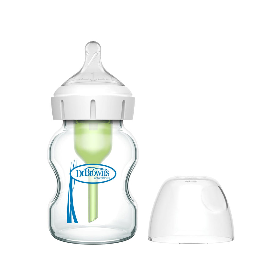 A Dr. Brown’s Natural Flow® Anti-Colic Options+™ Wide-Neck Glass Baby Bottle with a white cap, green internal vent, and Level 1 Slow Flow Nipple is shown beside a translucent cover on a white background.