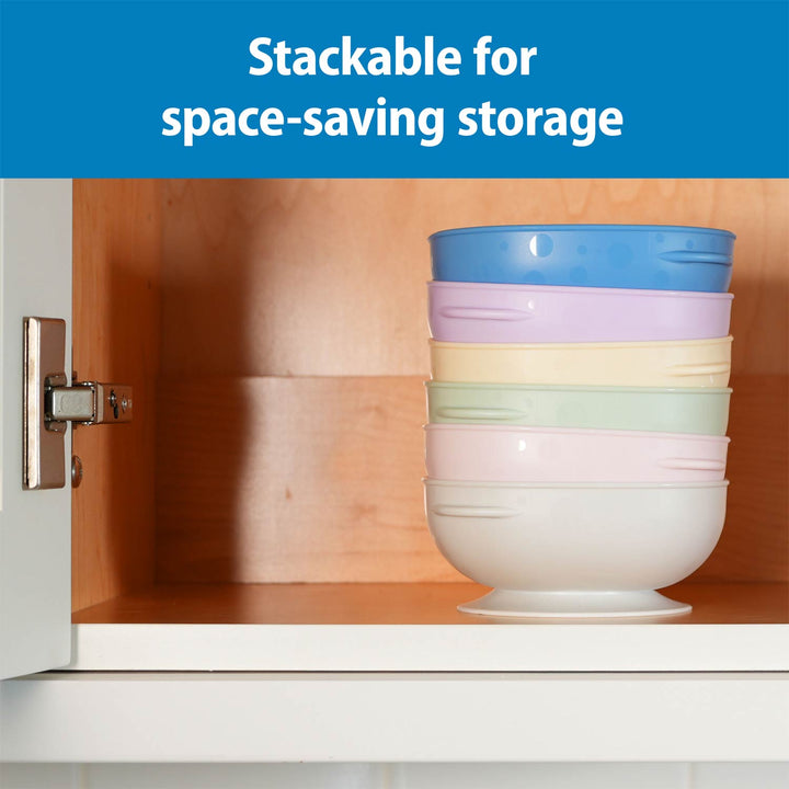 A stack of five No Slip Suction Bowls sits inside an open wooden cabinet, with a blue banner at the top reading 'Stackable for space-saving storage.