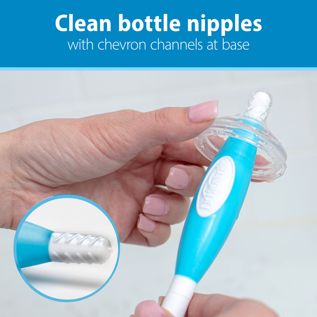 Using Dr. Brown’s™ Soft Touch Bottle Brush, made by Dr. Brown's, a person cleans a baby bottle nipple effortlessly. This brush is designed with durable bristles and a blue handle for effective, scratch-free cleaning while incorporating chevron channels at the base for added efficiency. Text at the top reads, "Clean bottle nipples with chevron channels at base.