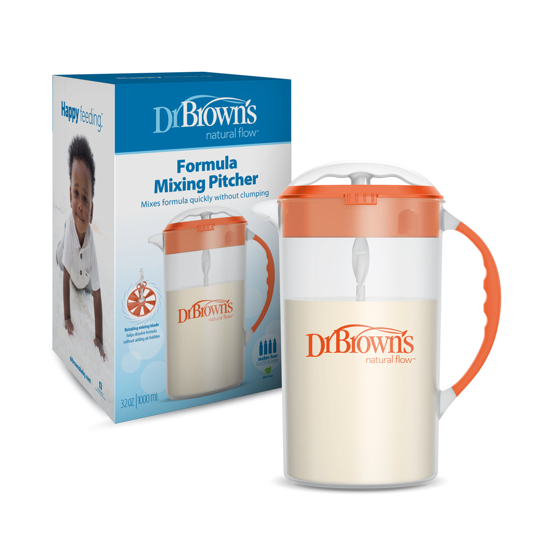 Dr. Brown's Natural Flow® Formula Mixing Pitcher, featuring an orange lid, is showcased next to its packaging that displays a baby and product information. This pitcher, engineered to minimize gas, is filled with white liquid to conveniently prepare formula before transferring it into baby bottles.