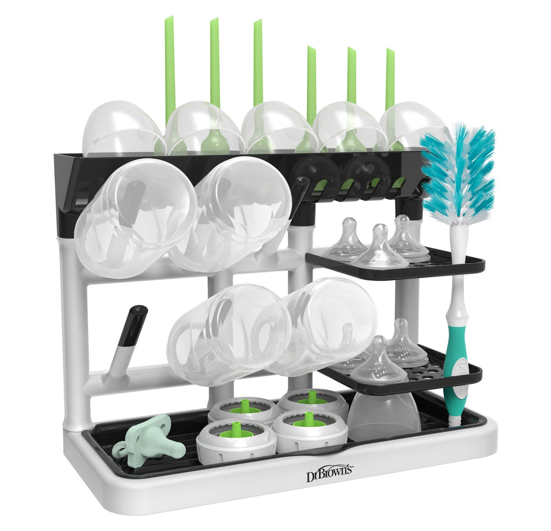 The Dr. Brown’s™ Drying Tower by Dr. Brown's is a countertop space saver that efficiently holds multiple baby bottles, nipples, and accessories. Designed as a vertical stand-up drying rack, it boasts a sleek white and black appearance with green accents on the straw holders and bottle brush for an organized and tidy setup.