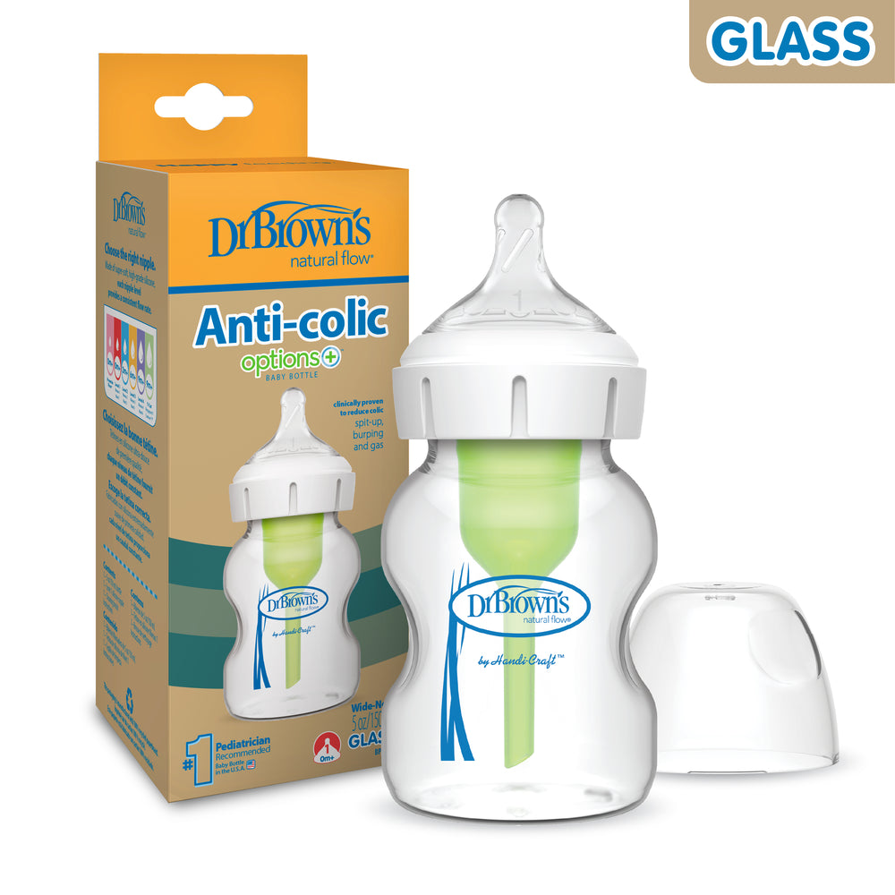  Dr. Brown’s Natural Flow® Anti-Colic Options+™ Wide-Neck Glass Baby Bottle is showcased, featuring a green anti-colic vent system and a clear Level 1 Slow Flow Nipple. Its natural flow design promotes comfort, and the white cap sits neatly beside it.