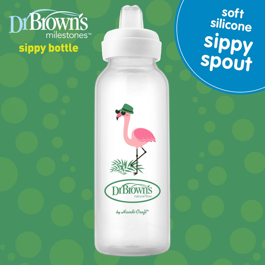 A Dr. Brown’s® Milestones™ Narrow Sippy Bottle, 8oz/250mL, 6m+, featuring a stylish pink flamingo wearing sunglasses and a green cap. The image emphasizes the "soft silicone sippy spout" feature, ideal for transitioning from bottle to cup, with the Dr. Brown's logo and the "Milestones" tagline set against a green polka dot background.