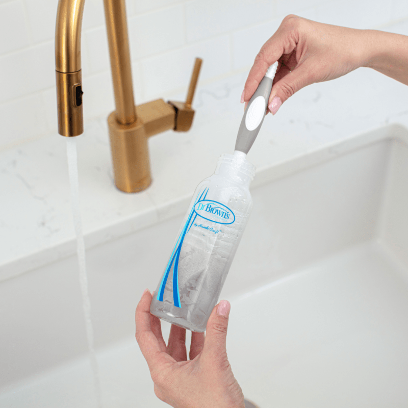 Baby bottle being washed with brush