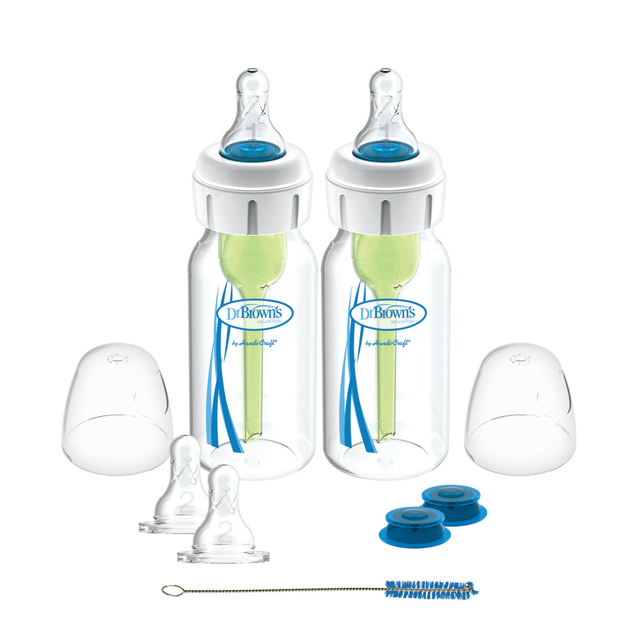 Displayed are two bottles from the Dr. Brown’s® Specialty Feeding System, 2 Count, featuring blue internal vent systems. These clear bottles with white lids come with bottle caps, spare nipples, a cleaning brush, and blue travel caps to address oral feeding issues.