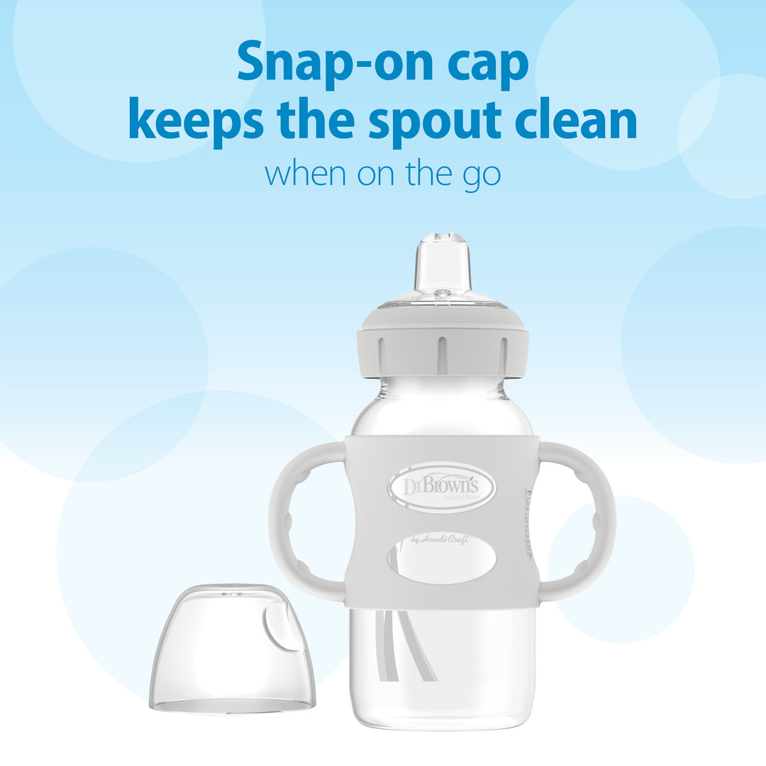 The Dr. Brown's Milestones™ Wide-Neck Sippy Spout Bottle with Silicone Handles, 9 oz/270 mL, is shown against a blue background. The accompanying text states, "Snap-on cap keeps the sippy spout clean when on the go.