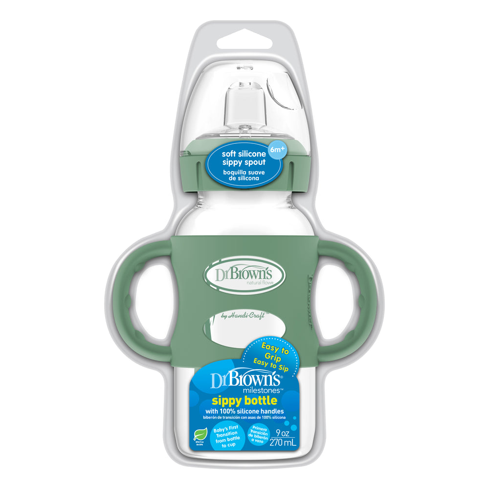 The Dr. Brown's® Milestones™ Wide-Neck Sippy Spout Bottle with Silicone Handles, featuring a soft spout and green silicone handles for easy gripping, is perfect for babies 6 months and older. This 270 mL (9 oz) bottle is packaged in a clear plastic case.